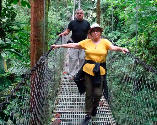 Turistas en puente colgante en bosque de Costa Rica